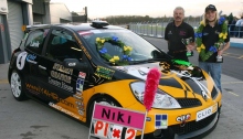 Niki Lanik avec ses médailles et sa voiture de course portant le logo de l’association Des jeunes pour les droits de l’Homme